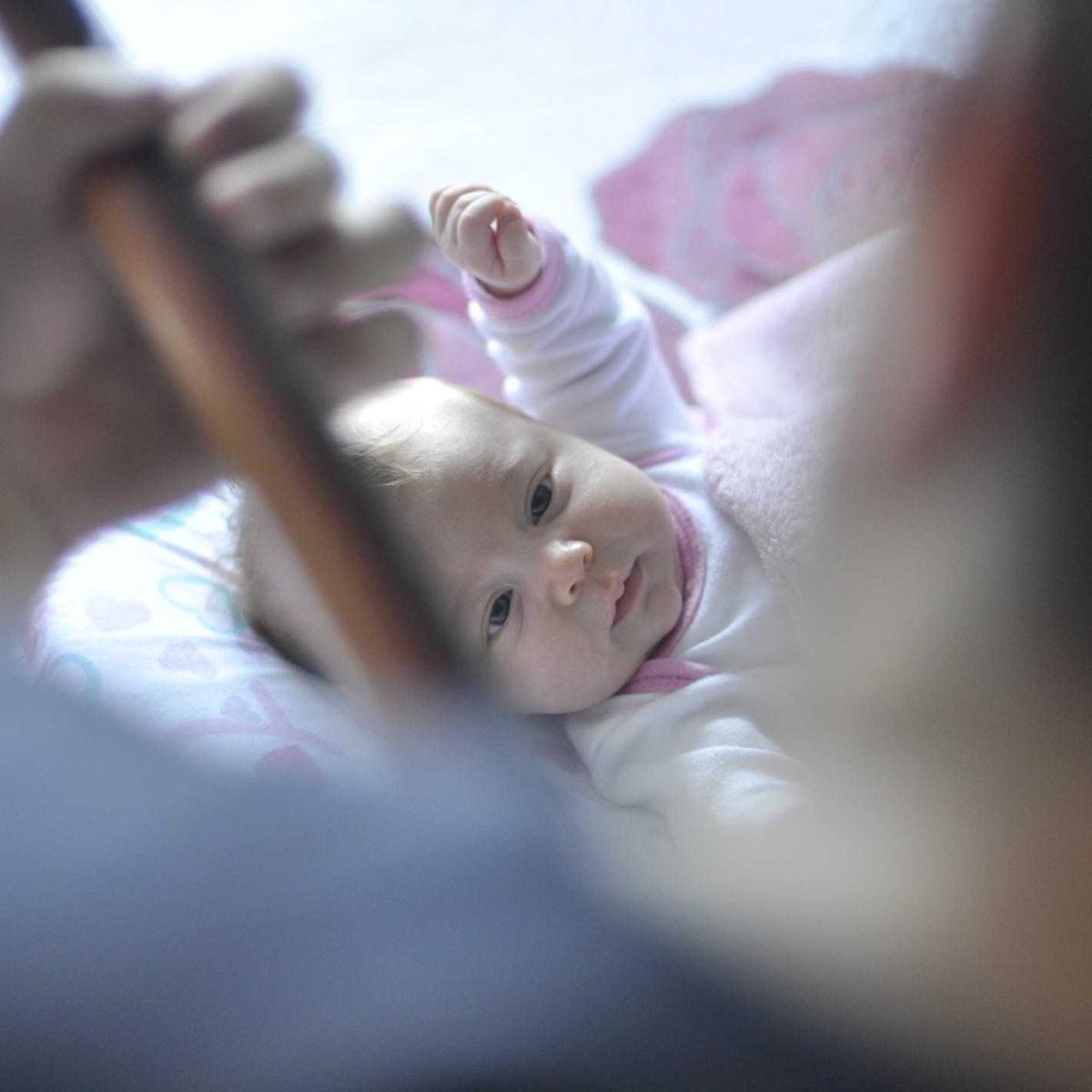 A baby lying on a soft blanket, looking up